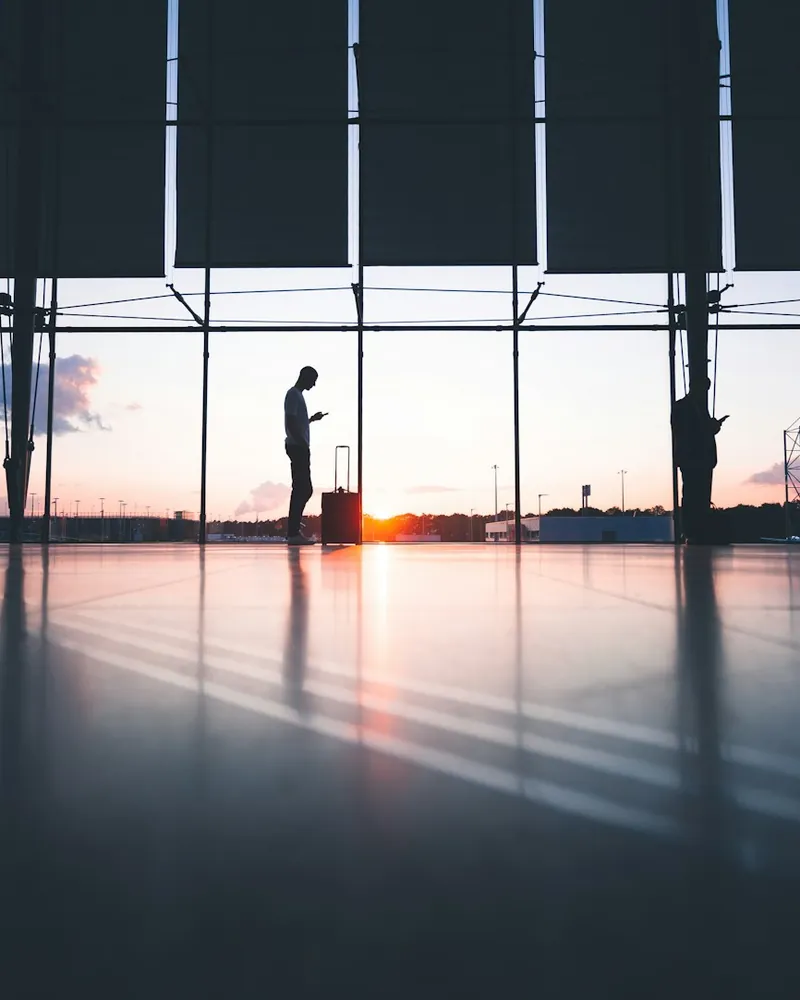 Travellers in an airport terminal at sunset, sample photo
